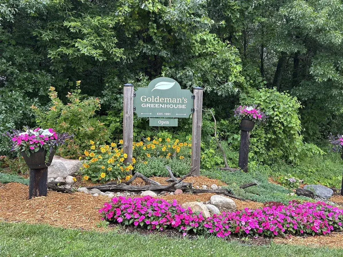 The Goldeman's Greenhouse sign surrounded by flowers on Durant Street